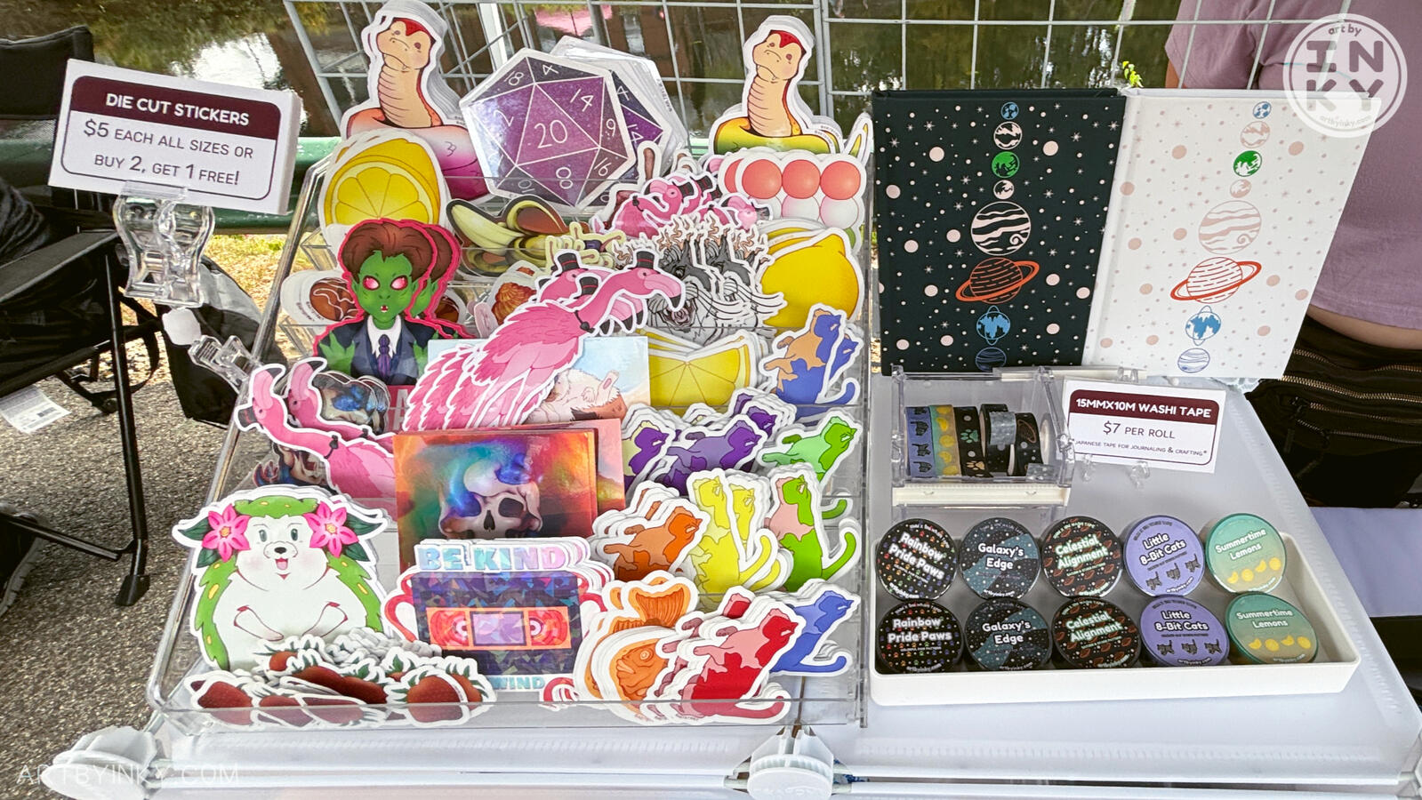 Front view of the booth layout at an outdoor market showing stationery.